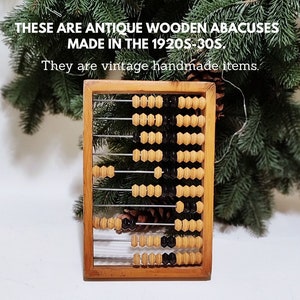 Puede incluir: Ábaco de madera antiguo de los años 1920-30. El marco es de madera, con filas de cuentas de madera y negras. El texto de la imagen dice: "Estos son ábacos de madera antiguos hechos en los años 1920-30. Son artículos vintage hechos a mano."