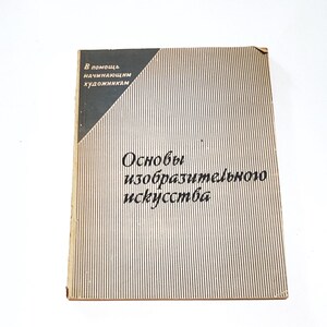 Op de afbeelding: Een vintage boek getiteld "Osnovy Izobrazitelnogo Iskusstva" in het Russisch, met een verticaal strepenpatroon en een donkergrijze driehoek in de linkerbovenhoek. Het boek is voor beginnende kunstenaars.
