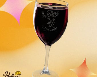 Puede incluir: Una copa de vino transparente llena de vino tinto oscuro. La copa presenta un gráfico grabado en blanco de un querubín sosteniendo una copa pequeña, sobre el texto blanco que dice Wine Not? El tallo y la base son transparentes.