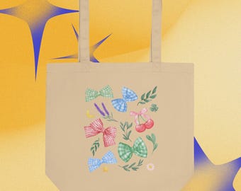 Puede incluir: Un bolso tote de color beige con un patrón estampado de varios lazos de cuadros vichy en rojo, azul y verde, junto con ilustraciones de cerezas rojas, ramitas de hojas verdes, una pequeña luna creciente amarilla, una estrella amarilla y una pequeña flor blanca.