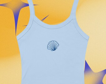 Puede incluir: Un top corto azul claro con tirantes finos y un diseño de concha marina azul oscuro. La parte superior está hecha de un material suave. El fondo es amarillo con formas de estrellas azules. Adecuado para climas cálidos.
