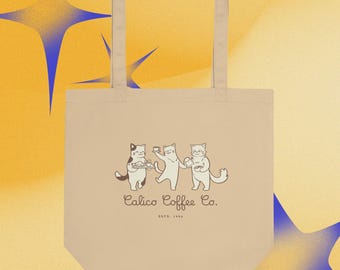Puede incluir: Bolso tote beige con tres gatos de dibujos animados sosteniendo café y una bandeja. El texto "Calico Coffee Co." y "ESTD. 1994" están impresos en negro. El bolso tiene dos asas y está hecho de un material suave.