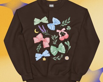 Puede incluir: Una sudadera de cuello redondo en color marrón oscuro con un estampado central de varios lazos de cuadros vichy en verde claro, azul y rosa, junto a ilustraciones de cerezas, ramas de lavanda, hojas verdes, una luna creciente amarilla y una flor.