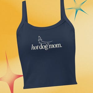 Puede incluir: Camiseta sin mangas azul marino con tirantes finos. El texto "hot dog mom" está impreso en blanco, junto con un dibujo lineal de un perro salchicha. La camiseta está hecha de un material suave y es perfecta para uso casual.
