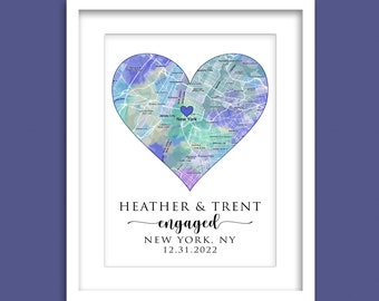 May include: Watercolor map of New York City in the shape of a heart with a small blue heart marking the location of New York City. The text "HEATHER & TRENT engaged NEW YORK, NY 12.31.2022" is below the map. The text "FRAMES ARE NOT INCLUDED 8X10 PRINT MATTED IN 11X14 FRAME" is below the text.