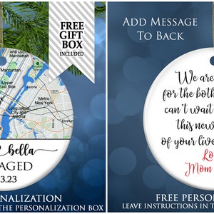 May include: A round white ceramic ornament featuring a map of New York City with a red heart icon, the names jack and bella, the word ENGAGED, and the date 11.23.23. The back displays black and red text reading We are so happy for the both of you.