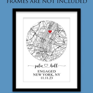May include: A black and white map of New York City with a red heart marking the location of Manhattan. The text "julie bill ENGAGED NEW YORK, NY 11.11.23" is below the map.