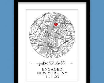 May include: A black and white map of New York City with a red heart marking the location of Manhattan. The text "julie bill ENGAGED NEW YORK, NY 11.11.23" is below the map.