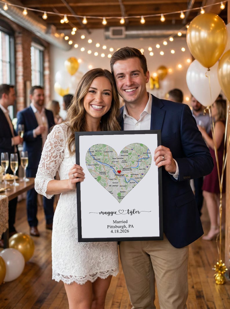 May include: A rectangular framed print featuring a heart-shaped map of Pittsburgh, Pennsylvania, with a red heart icon. Below the map, the text reads "maggie & tyler", "Married", "Pittsburgh, PA", and the date "4.18.2026" in black lettering.