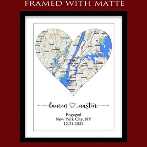 May include: A framed print with a white matte featuring a heart-shaped map of New York City with a red heart icon. Below the map, the text reads: FRAMED WITH MATTE, lauren heart austin, Engaged, New York City, NY, 12.31.2024 in black script and print.