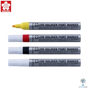 Può includere: Quattro pennarelli per vernice a basso contenuto di alogeni. I pennarelli sono giallo, rosso, nero e bianco. I pennarelli sono etichettati "Low Halogen Paint Marker" e hanno il testo "No abra aqui" sul lato.