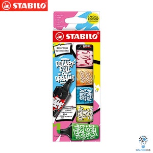 Pode incluir: Um conjunto de quatro marcadores Stabilo Boss Mini em uma embalagem colorida. Os marcadores são preto, rosa, amarelo e azul. A embalagem apresenta o texto "Pocket full of dreams" e "Stay true to the flow".