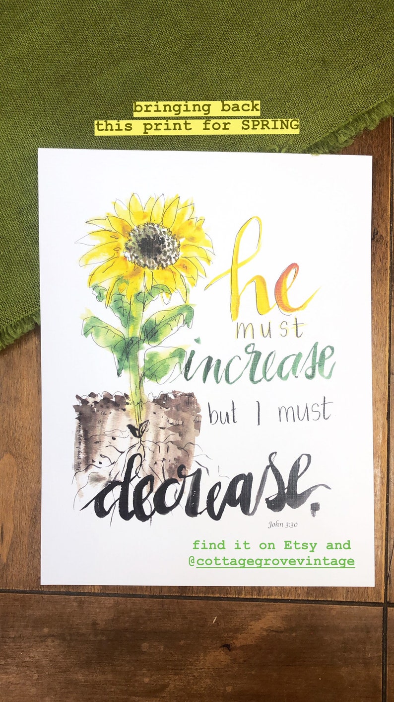 May include: A watercolor painting of a sunflower with the text "he must increase but I must decrease" and the scripture reference "John 3:30". The painting is on a white background and has a green and brown watercolor wash around the sunflower.
