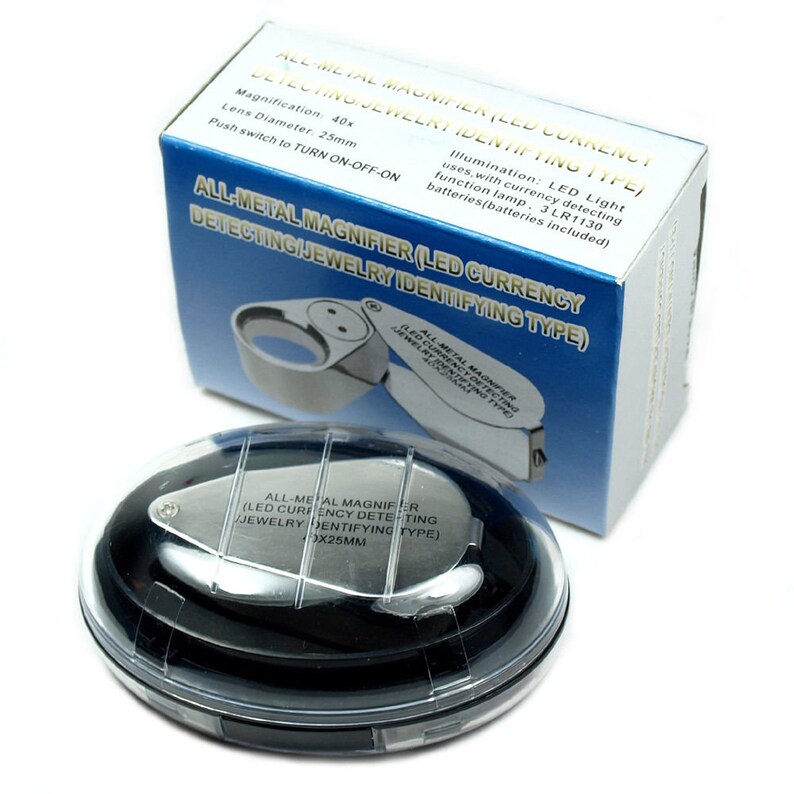 May include: A silver magnifying glass with a built-in LED light, in a clear plastic case. The magnifying glass is labeled "All-Metal Magnifier (LED Currency Detecting/Jewelry Identifying Type)" and has a magnification of 40x. The lens diameter is 25mm.