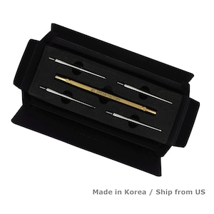 May include: A black box set containing a gold-colored tool with the text "DREAM FACTORY" and four silver-colored tools. The tools are arranged in a black foam insert. The box is open, revealing the contents.