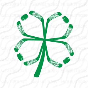 May include: Green shamrock design made from four hockey sticks and four pucks. The sticks are crossed in the center and the pucks are placed at the ends of each stick.