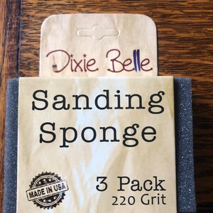 May include: A pack of three sanding sponges, 220 grit, made in the USA. The packaging is labelled "Dixie Belle Sanding Sponge 3 Pack 220 Grit".