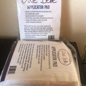 May include: A white terry cloth applicator pad packaged in a clear plastic bag. The bag has a label with the text "Dixie Belle Applicator Pad" and instructions for using the pad with various paint and wax products.