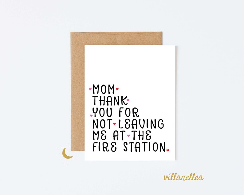 May include: A white card with a handwritten message that reads "Mom, thank you for not leaving me at the fire station." The card has small pink hearts around the text.