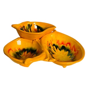 May include: A yellow ceramic serving dish with three bowls. The bowls have a swirl design in shades of yellow, orange, green, and black.
