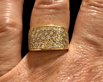 May include: A gold band ring with a wide, rectangular setting encrusted with small, clear diamonds.