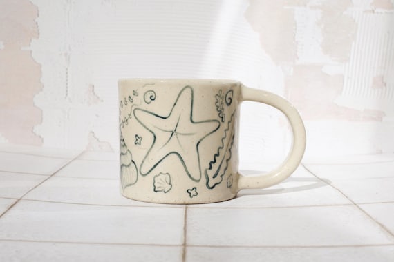 Handmade Stoneware Coffee Mug: 335ml Hand-Painted Shell illustration