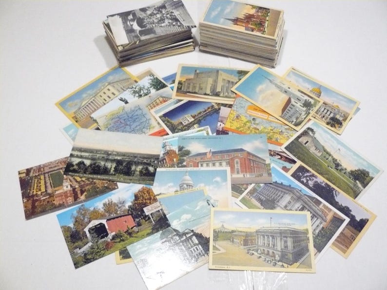 May include: A collection of vintage postcards featuring various landmarks and scenes. The postcards depict buildings, landscapes, and historical sites, with a mix of color and black-and-white images. Some are stacked, others are scattered.