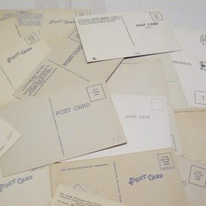 May include: A collection of vintage postcards, some with the words "POST CARD" printed on them. The postcards are in various shades of cream and beige, with some featuring text and images.