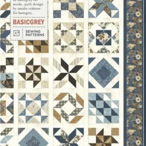 May include: A patchwork quilt with a blue and white color scheme, featuring geometric patterns and floral borders. The quilt design includes squares, diamonds, and starbursts. The text "PRISMS IN BLUE" and "PAT047" are visible.