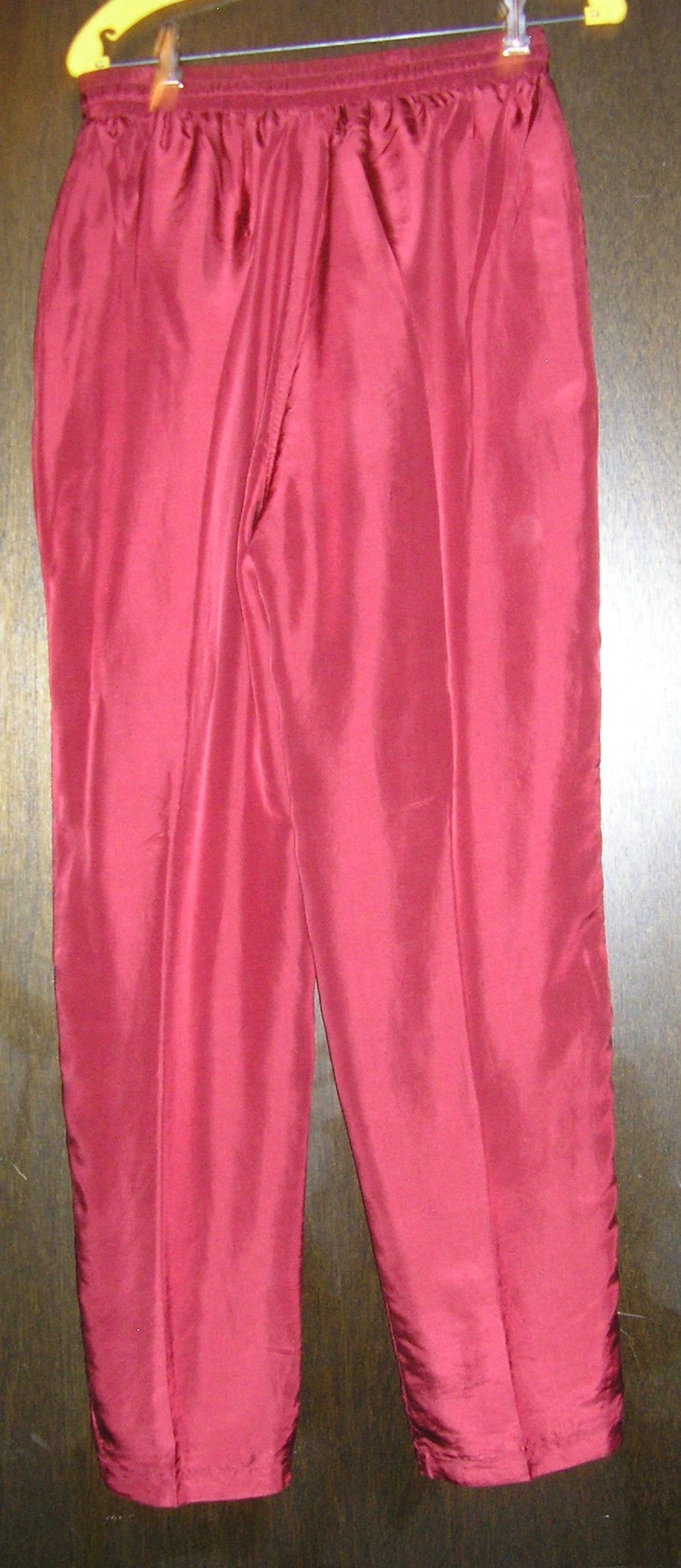 May include: A pair of burgundy sweatpants with a drawstring waist.