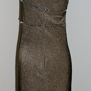 May include: A black sequined sleeveless dress with a scoop neck and a fitted silhouette. The dress has a beaded trim around the neckline and waist.