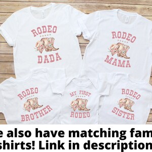 May include: Set of five white t-shirts with pink text and graphics. The shirts say "Rodeo Dada", "Rodeo Mama", "My First Rodeo", "Rodeo Brother", and "Rodeo Sister".