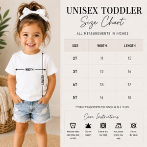 May include: A white t-shirt size chart for toddlers featuring a child wearing a plain white t-shirt and denim shorts. The chart lists sizes 2T through 5T with width and length measurements in inches, plus care instructions with icons and text.