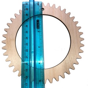 One of the wood circle looms next to a ruler for scale.