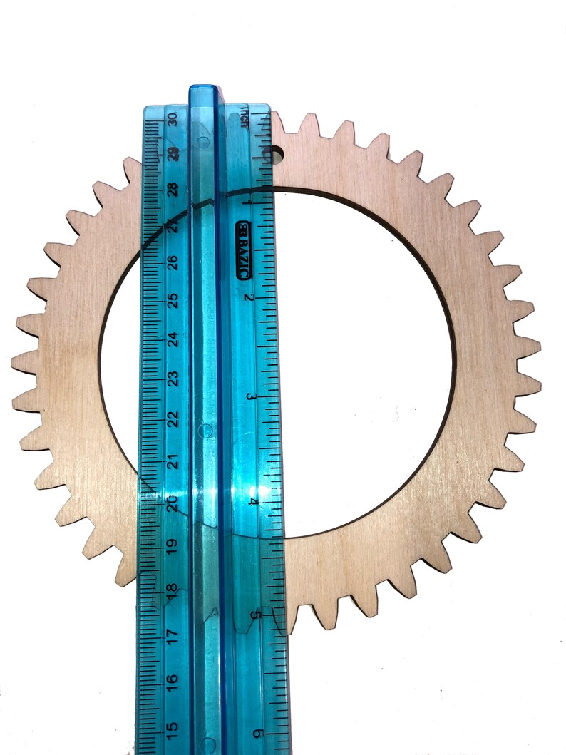 One of the wood circle looms next to a ruler for scale.