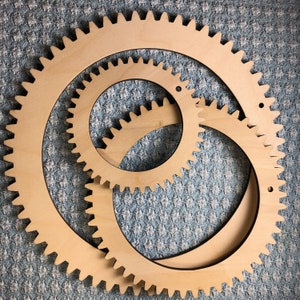 The photograph shows 3 circle looms. The 3 looms in this set are different sizes and are all made from birch plywood. The circle looms are each a natural wood color.