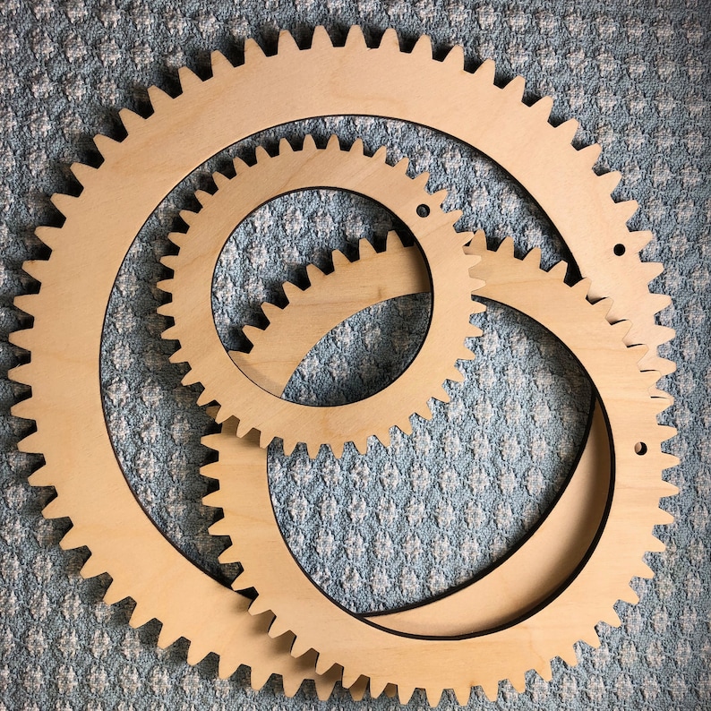 The photograph shows 3 circle looms. The 3 looms in this set are different sizes and are all made from birch plywood. The circle looms are each a natural wood color.
