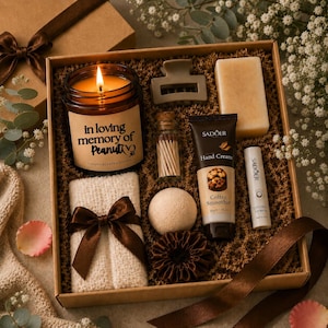 Peut inclure: Un coffret cadeau rempli d'articles de bien-être. Il comprend une bougie allumée avec du texte, une pince à cheveux, du savon, des allumettes, de la crème pour les mains, un baume à lèvres, un gant de toilette avec un nœud, une bombe de bain et un chouchou.