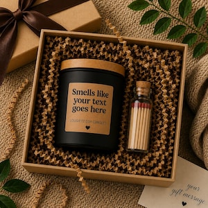 May include: A black soy candle in a jar with a wooden lid and a tan label reading Smells like your text goes here LOUGIFTZ SOY CANDLES with a heart icon, accompanied by a small glass bottle of matches inside a brown gift box with crinkle paper.