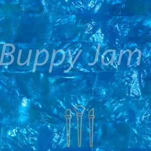 May include: A close-up of a blue iridescent tile sheet. The tile sheet is made of mother of pearl and has a shimmering, pearlescent finish. The tile sheet is perfect for adding a touch of elegance to any room.