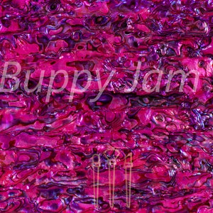 May include: Close-up of a pink and purple iridescent abalone shell with a swirling pattern. The shell has a glossy finish and a textured surface.