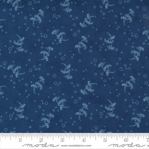 May include: A blue fabric with a white floral pattern. The fabric has a subtle texture and a repeating pattern of small white flowers. The fabric is shown with a ruler for scale.