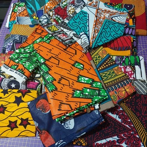 May include: A collection of colorful fabric scraps with various patterns, including geometric designs, floral motifs, and abstract shapes. The fabrics are arranged in a pile, showcasing a variety of colors and textures.