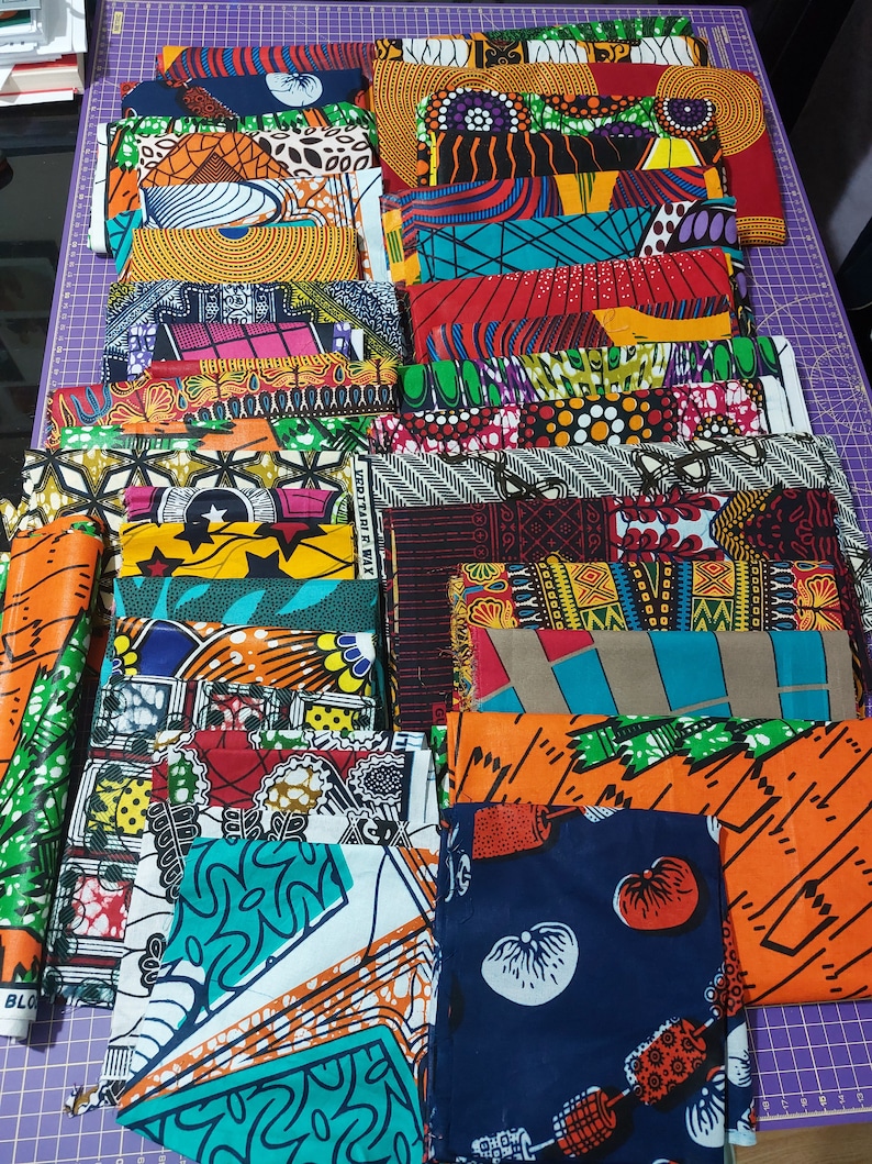 May include: A collection of colorful fabric squares with various patterns, including geometric designs, floral motifs, and abstract shapes. The fabrics are arranged in a stack, showcasing a variety of colors and textures.
