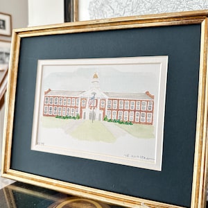 May include: A framed watercolour painting of a brick school building with a white steeple and a flagpole with an American flag. The building has a sign that reads "London Elementary High School". The painting is signed "K. Anna Starr" in the bottom right corner.