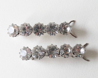 May include: Two silver hair clips with clear rhinestone accents. Each clip has five rhinestones.
