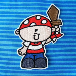 May include: A red and white cartoon pirate with a brown sword, wearing a red and white striped shirt and blue pants.