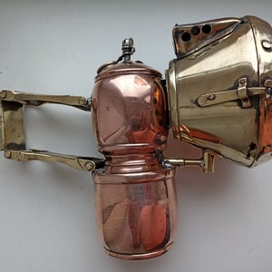 Può includere: Una lampada vintage in ottone e rame con un braccio snodato e un riflettore. La lampada ha un design decorativo ed è in buone condizioni.