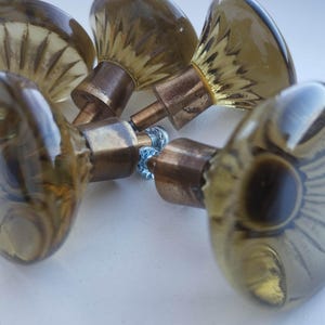 Ensemble de 5 boutons de meuble vintage suédois du milieu du siècle, en verre olive et laiton, style Lindshammar classique.