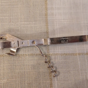 以下が含まれることがあります： ハンドルに「Skyline Made in England」と刻印された、銀色の缶切りとコルク抜きを組み合わせたツールです。